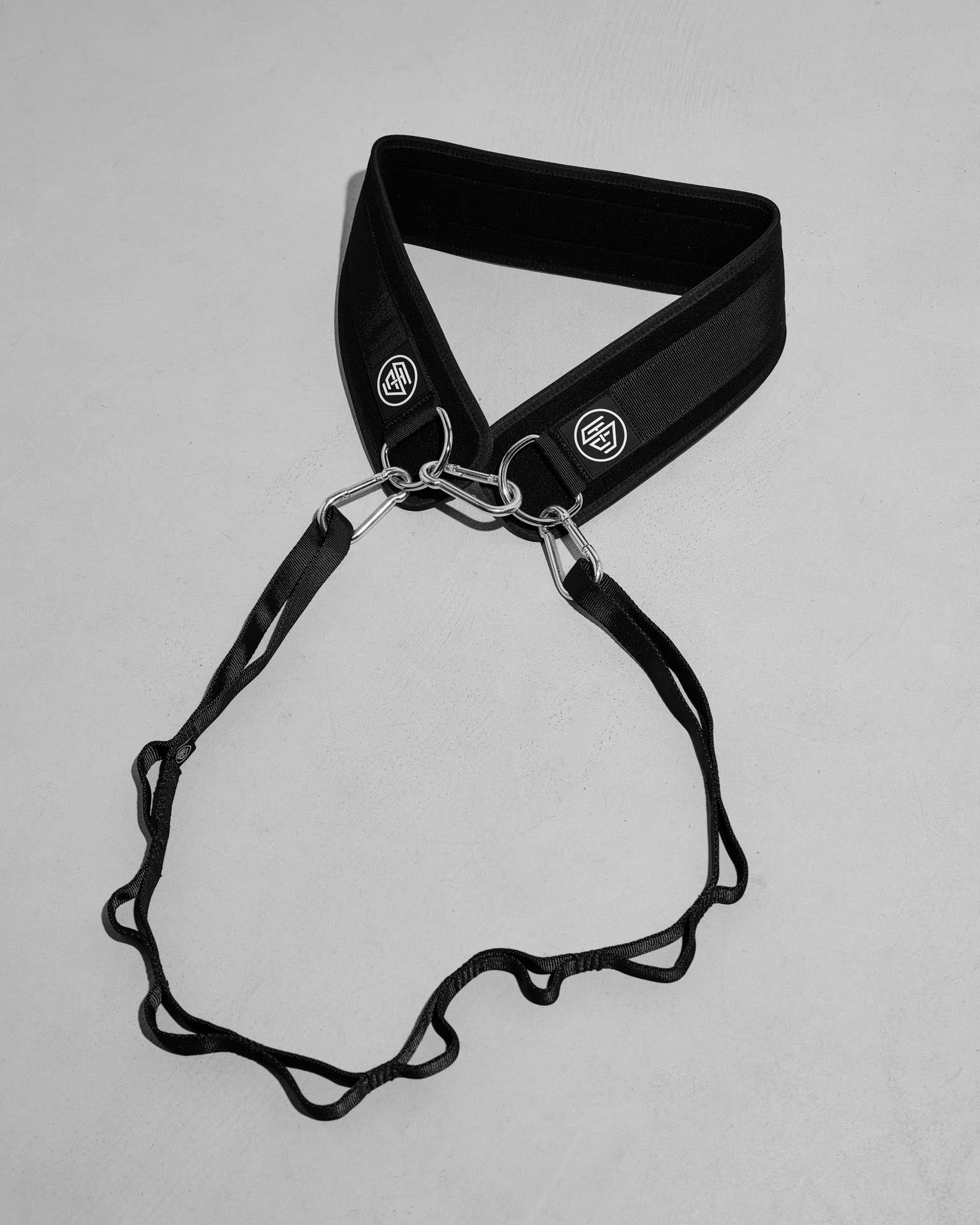 Black weight belt with metal clip on a gray background