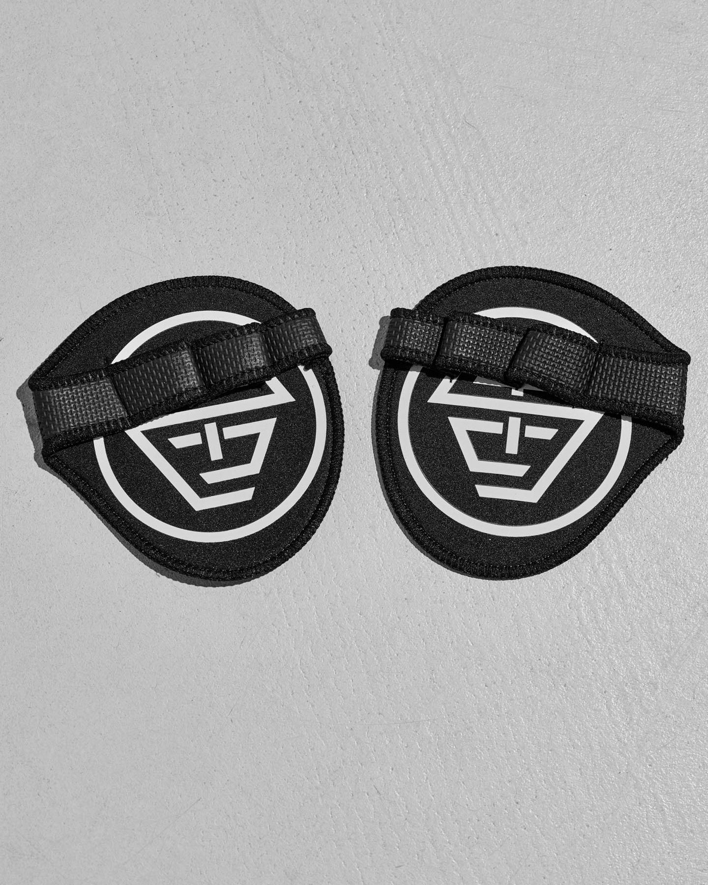 Two black protective grip pads with the STC logo on a gray background