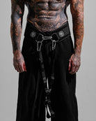 Person wearing black pants with a belt and carabiner on a gray background