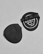Two black protective grip pads with the STC logo on a gray background