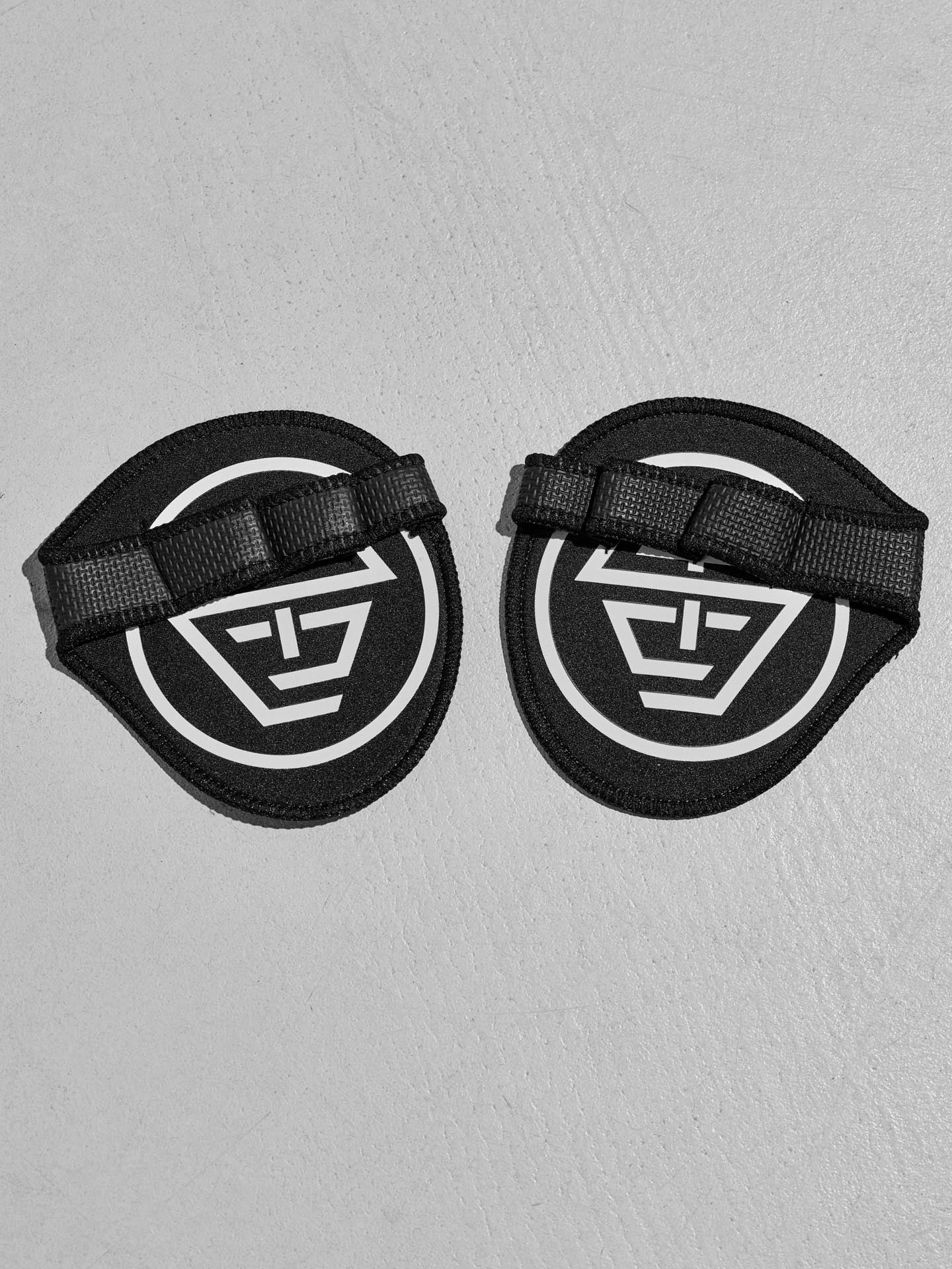 Two black protective grip pads with the STC logo on a gray background